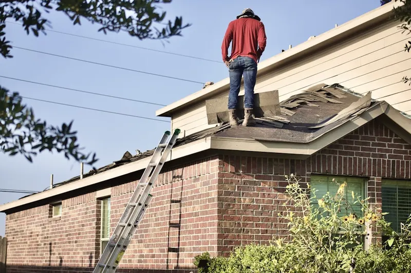 Professional roofer working on a residential roof in Suffolk Downs
